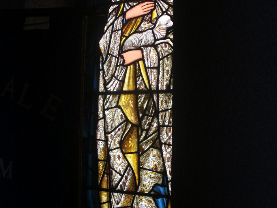 An image of a stained glass window showing a woman posing with the word humility above her